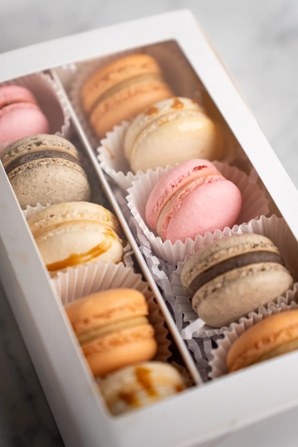 A fall assortment of handmade macarons in a white gift box